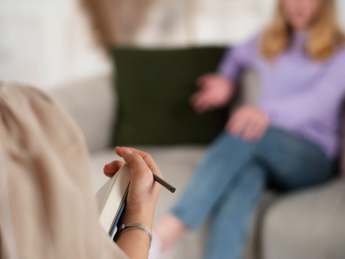 Sessions Client sitting in therapy session with counsellor taking notes